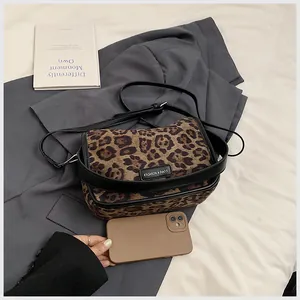 Détail d'un sac bandoulière léopard à côté d'un smartphone montrant la taille réelle