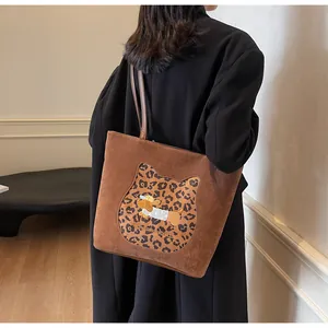 Detail of large brown suede tote bag with leopard cat patch and dog embroidery