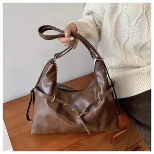Detail of deep brown Hobo shoulder bag with metallic buckle and retro PU leather texture