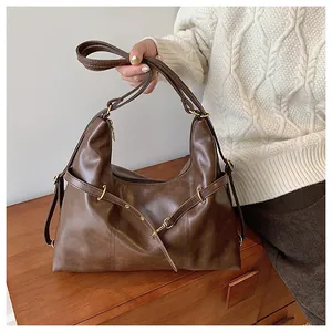 Close-up of brown matte soft leather tote bag featuring golden buckle and retro texture
