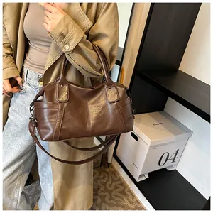 Detail of dark brown tote bag with smooth leather finish and detachable shoulder strap