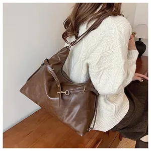 Detail of vintage brown large capacity shoulder bag with gold hardware and smooth texture