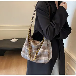 Vue détaillée d'un sac hobo à carreaux avec bandoulière en cuir et chaîne dorée