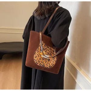 Detail of suede tote bag featuring leopard print horse-shoe patch and cat embroidery