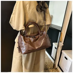 Close-up of deep brown tote bag with leather texture and adjustable shoulder strap