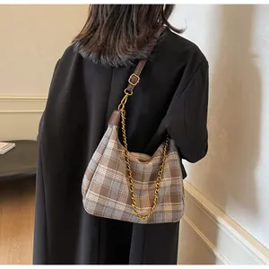 Détail du sac hobo à carreaux rétro avec bandoulière en cuir et chaîne dorée décorative
