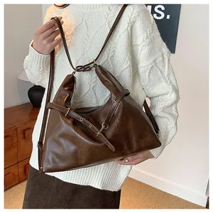 Detail of soft dark brown leather shoulder bag with vintage metal adjustable buckle strap