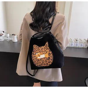 Macro detail of black suede backpack featuring leopard cat and cartoon dog embroidery