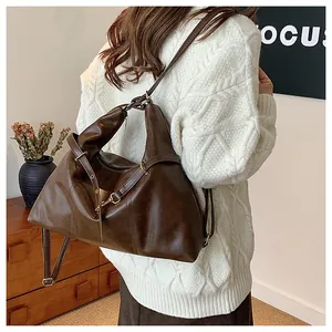 Detailed view of the dark brown leather tote bag with metallic ring and adjustable strap