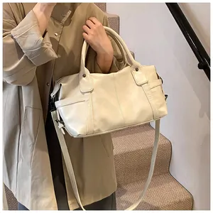 Detail of soft cream faux leather tote bag showing side pockets and vertical stitching