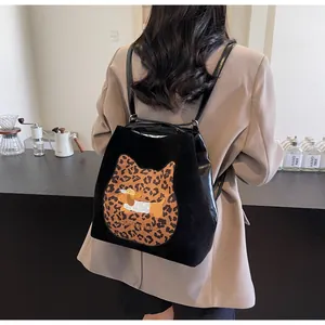 Detail of black backpack with leopard cat pattern and dachshund embroidery on model