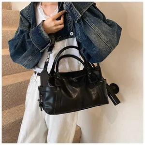 Model wearing a large black leather tote bag on a staircase for casual fashion styling