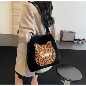 Detail of black tote bag with leopard cat and dog embroidery in a lifestyle setting