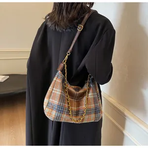 Détail du sac à bandoulière en tweed à carreaux avec chaîne dorée et sangle en cuir