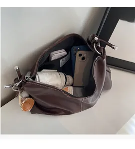 Interior view showing the large capacity and zipper pocket of the brown bucket bag