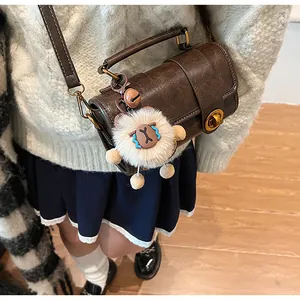 Détail du sac polochon vintage marron avec fermoir doré et pendentif agneau doux