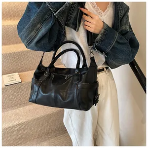 Detail of a black PU leather tote bag featuring silver hardware and a detachable strap