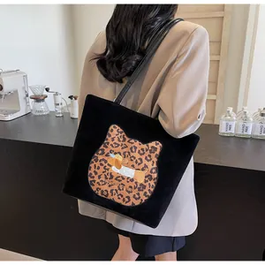 Detail of a black tote bag with leopard cat patch and dachshund embroidery on front
