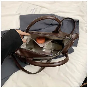 Top view of large brown tote bag interior with multiple compartments for cosmetics