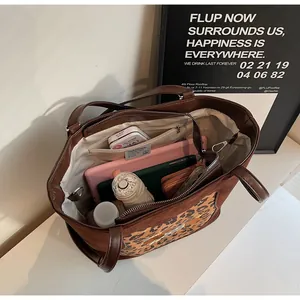 Detailed interior of a large leopard tote bag showing spacious compartments and items