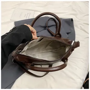Detailed interior of deep brown tote bag showing gray lining and internal pockets