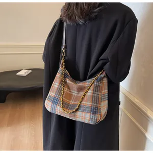 Détail du sac cabas à carreaux avec bandoulière en cuir marron et chaîne dorée
