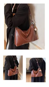 Detail of retro brown bucket bag with contrast white stitching and woven knot strap