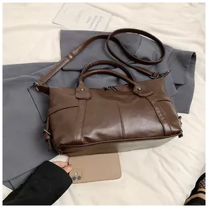 Detail view of the vintage brown matte leather tote bag with handles and adjustable strap