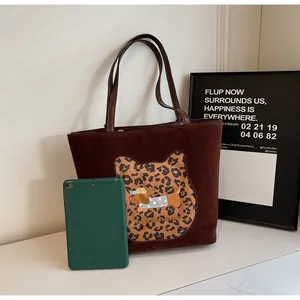 Detailed close-up of dark brown tote bag with leopard print cat and dog embroidery