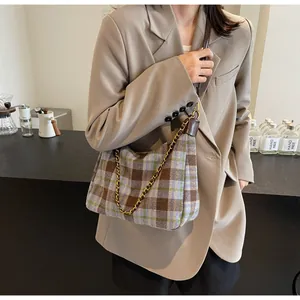 Détail du sac à bandoulière en tweed à carreaux et chaîne avec un blazer beige