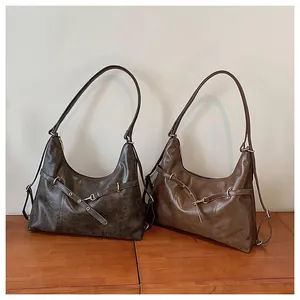 Detail of retro leather hobo bags in black and brown with elegant gold buckle hardware