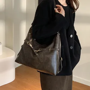Brown leather large capacity tote bag worn by model in a minimalist indoor setting