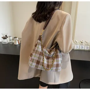 Détail du sac à bandoulière en tweed à carreaux bleu et marron avec chaîne dorée