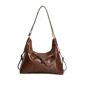 Brown half-moon hobo bag in polished leather with adjustable strap for commuting