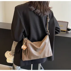 Detail of coffee brown PU leather bucket bag with braided knot strap and star charm