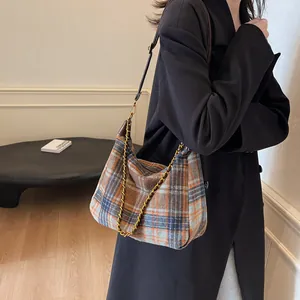 Sac bandoulière rétro en laine écossaise avec chaîne dorée porté par un mannequin