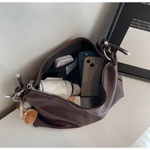 Detail view of large capacity dark brown leather bucket bag with internal storage compartments