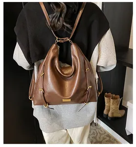 Detail view of large dark brown tote bag with metallic hardware and leather texture
