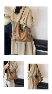 Detail view of coffee brown faux leather hobo bag with gold hardware on a model