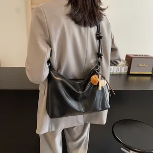 Versatile black PU leather bucket bag with white stitching and sports charms