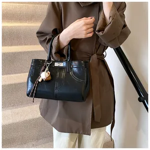Black glossy leather tote bag featuring a sporty baseball charm and silver twist lock