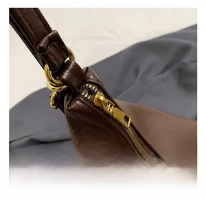 Close-up of vintage brass hardware and high-quality zipper on a chocolate tote bag