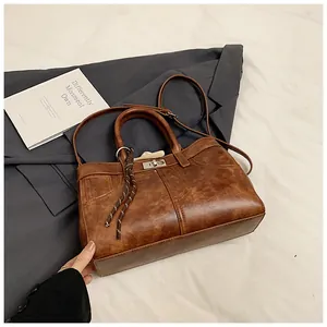 Detailed view of vintage brown leather bag with metallic twist lock and denim pocket stitch