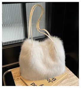 Detail van de pluizige witte faux fur textuur en slanke lederen handgrepen op de tas