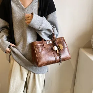 Retro brown leather tote bag for women with unique stitching and baseball theme pendants