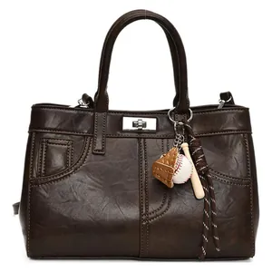 Retro brown leather tote bag with vintage stitching and baseball glove charm
