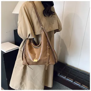 Brown leather large tote bag detail showing gold buckle and soft textured side strap