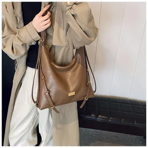 Detail shot of the brown leather tote bag side straps and gold buckle accessories