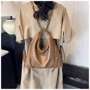 Close-up of soft brown leather tote bag with gold buckle hardware and fine texture