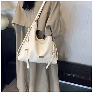 Detail of cream oversized hobo tote bag featuring textured leather and adjustable straps